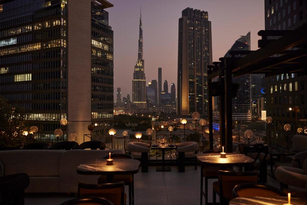 a rooftop restaurant with a view of the city at night at Four Seasons Hotel Dubai International Financial Centre in Dubai