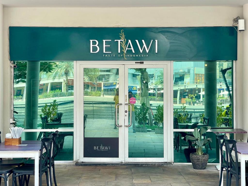 a restaurant with a green awning over the door at Rustic Elegance By The Lake Studio Cabin In Jlt in Dubai