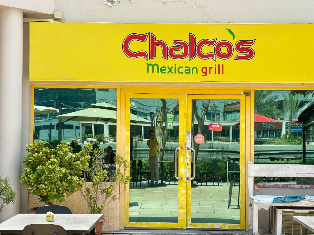 a sign for a mexican grill in front of a restaurant at Rustic Elegance By The Lake Studio Cabin In Jlt in Dubai