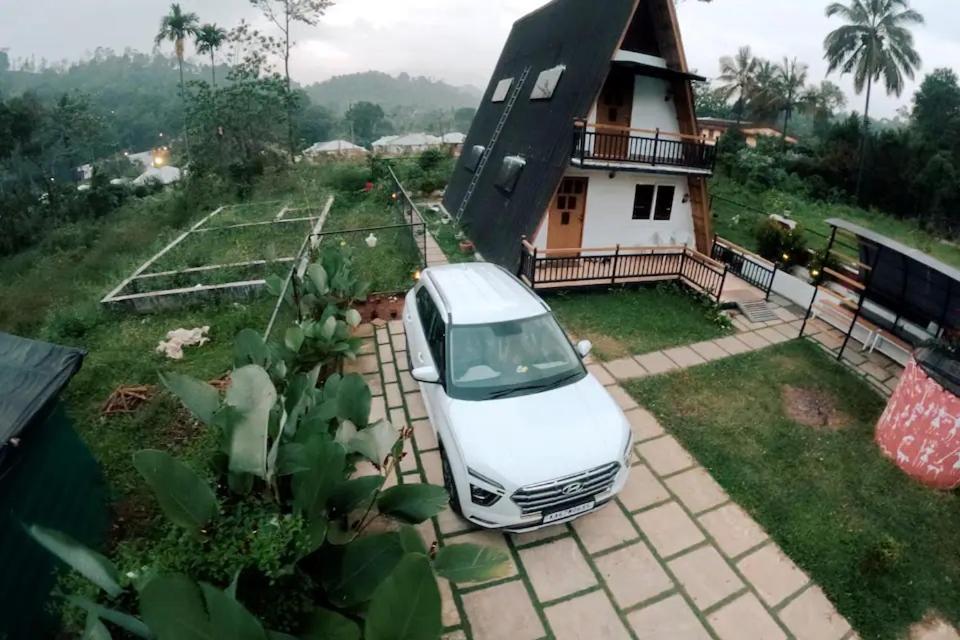 ein weißes Auto, das vor einem Haus parkt in der Unterkunft Hill View 'A'Frame Villa Wayanad in Vythiri