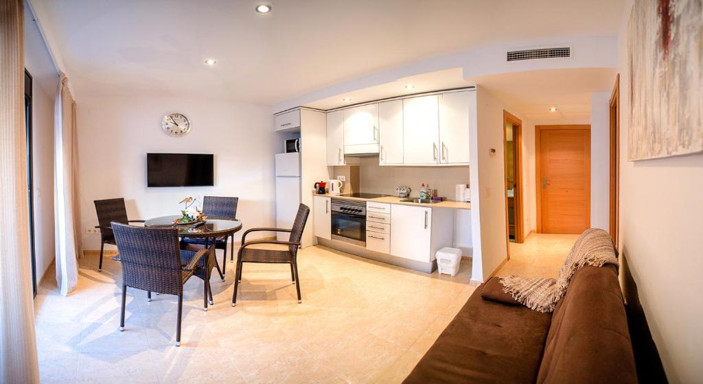 a living room and kitchen with a couch and a table at Parrot’s House in Lloret de Mar