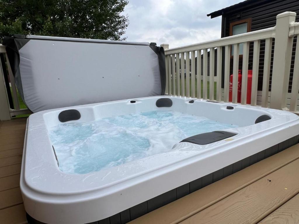 a hot tub sitting on top of a deck at Lottie's Lodge With Hot Tub in Malton