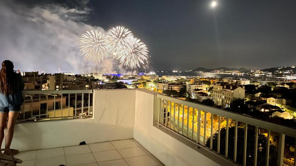 une femme debout sur un balcon regardant des feux d'artifice dans l'établissement FIREWORKS VIEW - 6 Persons, à Antibes