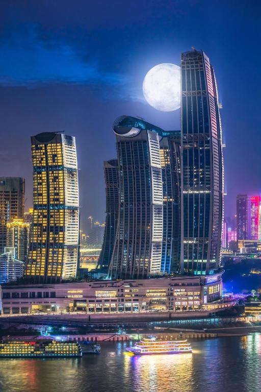 La luna creciente se eleva sobre una ciudad por la noche en 重庆陌隅酒店 - 人民大礼堂地铁站店, en Chongqing