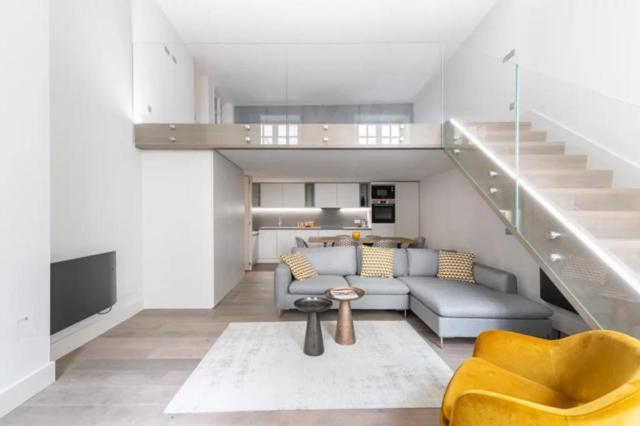 un salon avec un canapé et un escalier dans l'établissement Marais - Temple, à Paris