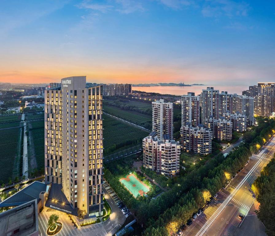 una vista aérea de una ciudad por la noche en Doubletree By Hilton Yantai Golden Coast Hotel &amp; Suites, en Yantai