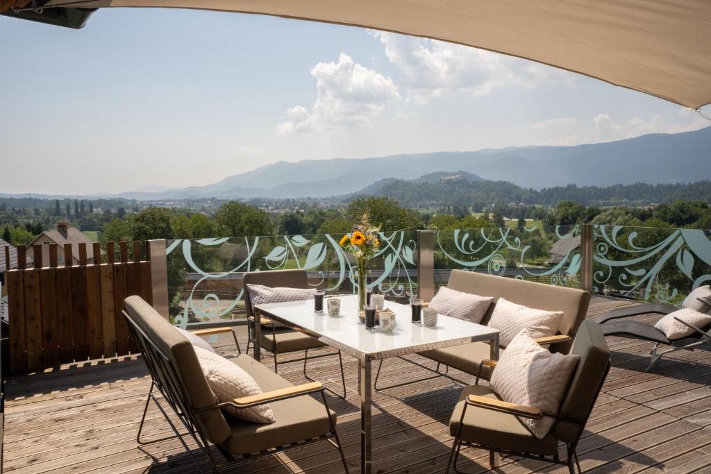 patio ze stołem i krzesłami na tarasie w obiekcie Aparthotel Hom at Vintgar w mieście Zgornje Gorje