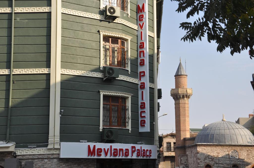 a building with a sign in front of a mosque at Mevlana Palace in Konya