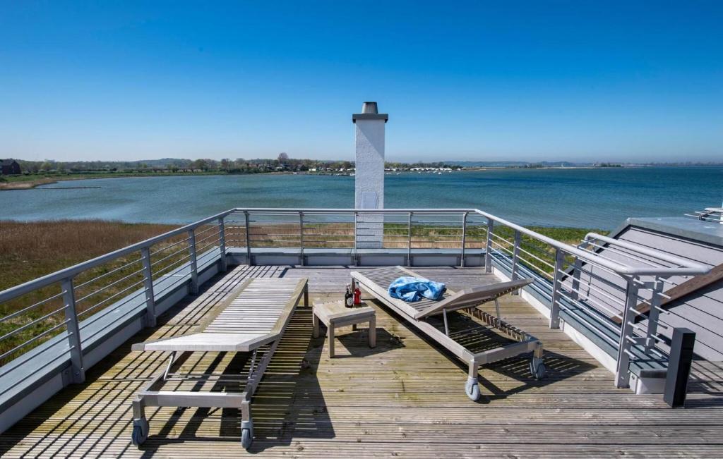 a dock with a bench and a table and a lighthouse at Villa Kunterbunt in Olpenitz