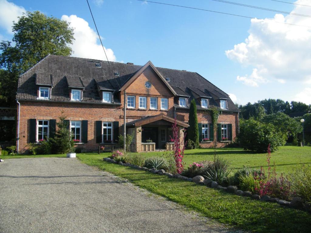 a brick house with a black roof at Gutshaus Dämelow Wismar in Dämelow