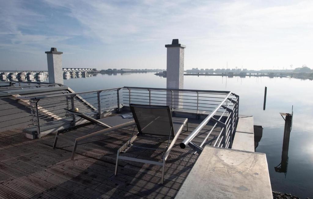 a dock with a chair sitting on top of the water at Lillehuus in Olpenitz
