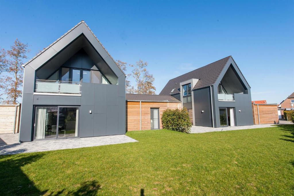 a modern house with a large yard at Ferienwohnung 2 (rollstuhlgerecht), Hoddersdiek 1 in Hoddersdeich