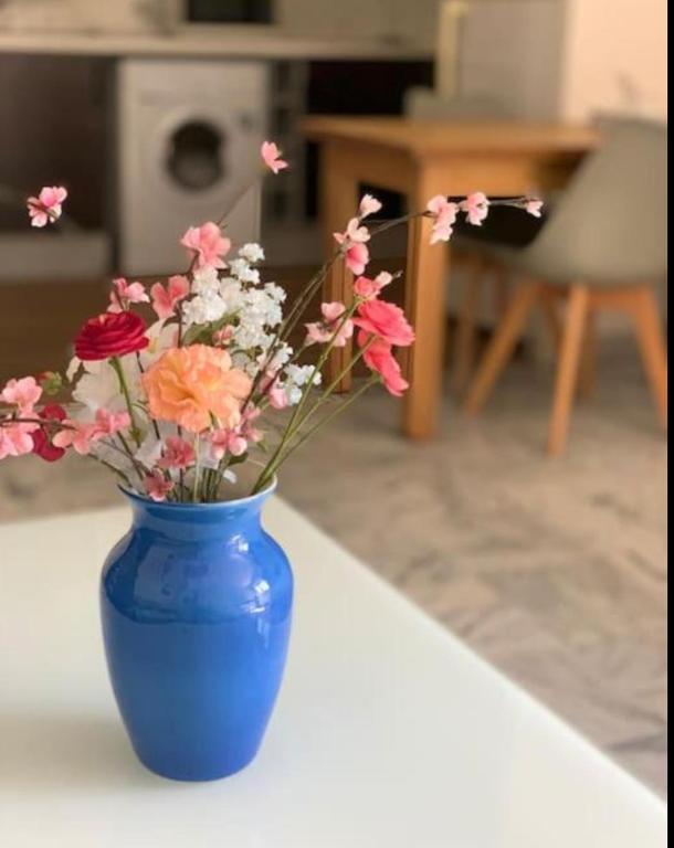 un vase bleu rempli de fleurs sur une table dans l'établissement spacieux Bel appartement 4 personnes centre Menton, à Menton