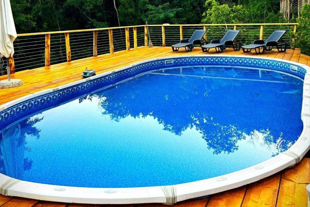 una piscina con sedie e una terrazza in legno di AgriGlamping La Diaccia a Serravalle Pistoiese