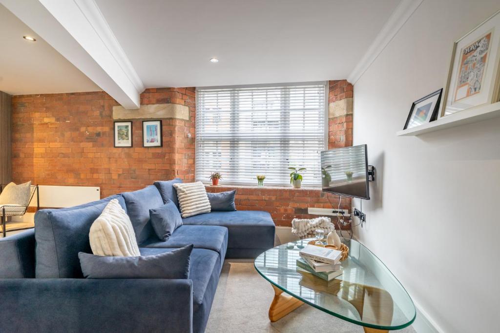 a living room with a blue couch and a glass table at Cocoa Loft - parking included in York
