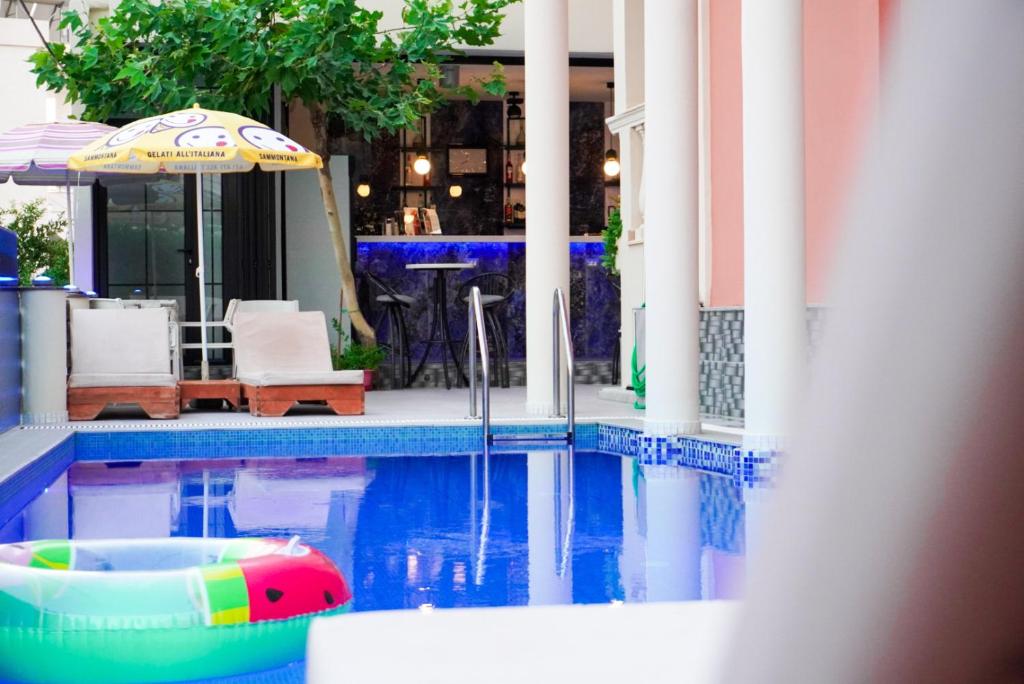 a swimming pool with an umbrella and an inflatable at Marku Palace in Ksamil