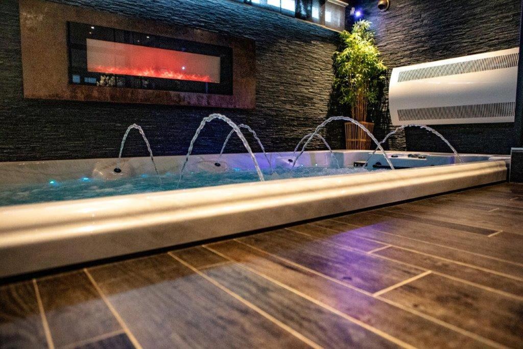 a hot tub with faucets in a room at Suite Wellness in Sprimont