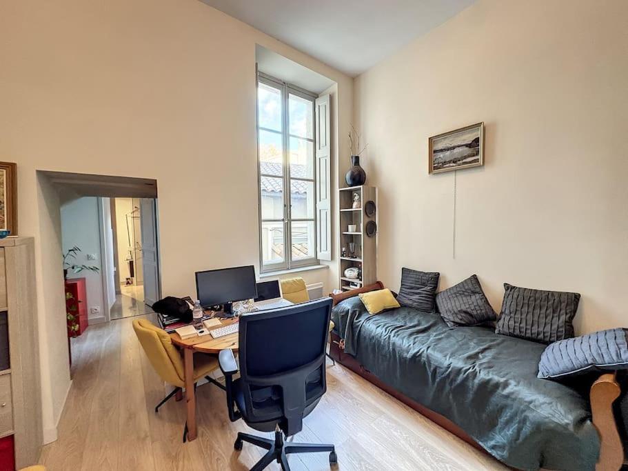 - un salon avec un canapé et un bureau avec un ordinateur dans l'établissement Appartement IM T2 ds hôtel particulier proche Palais des Papes, à Avignon
