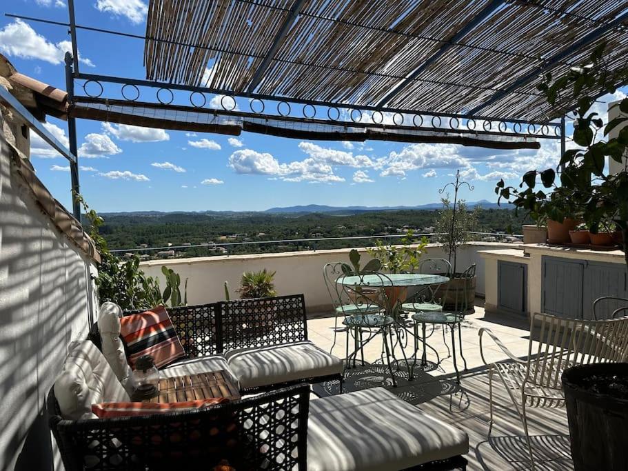 a patio with a table and chairs on a balcony at Jolie maison atypique in Vézénobres