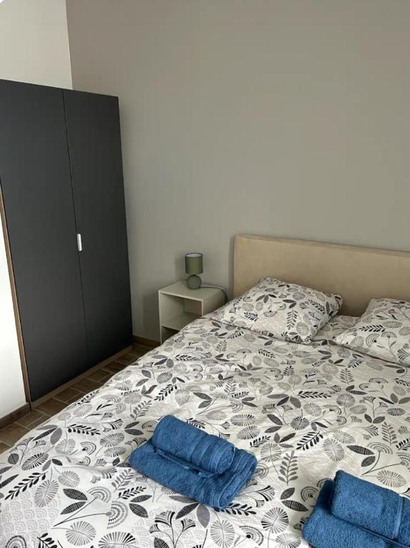 - une chambre avec 2 oreillers bleus sur un lit dans l'établissement Appartement avec cours extérieur, à Trévières