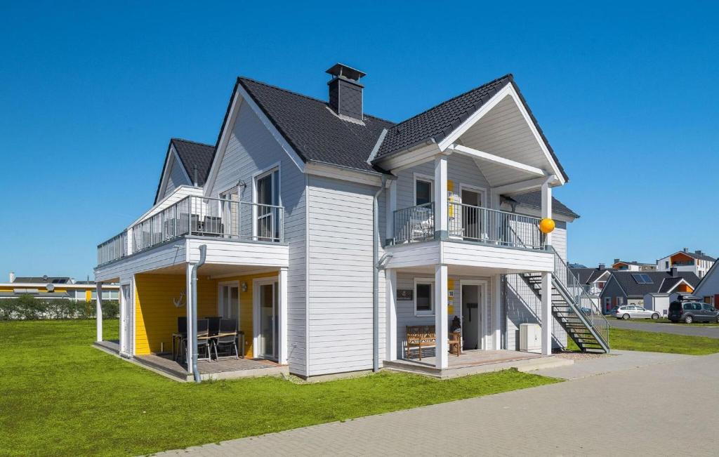 a large white house with a black roof at Strand 11 in Olpenitz