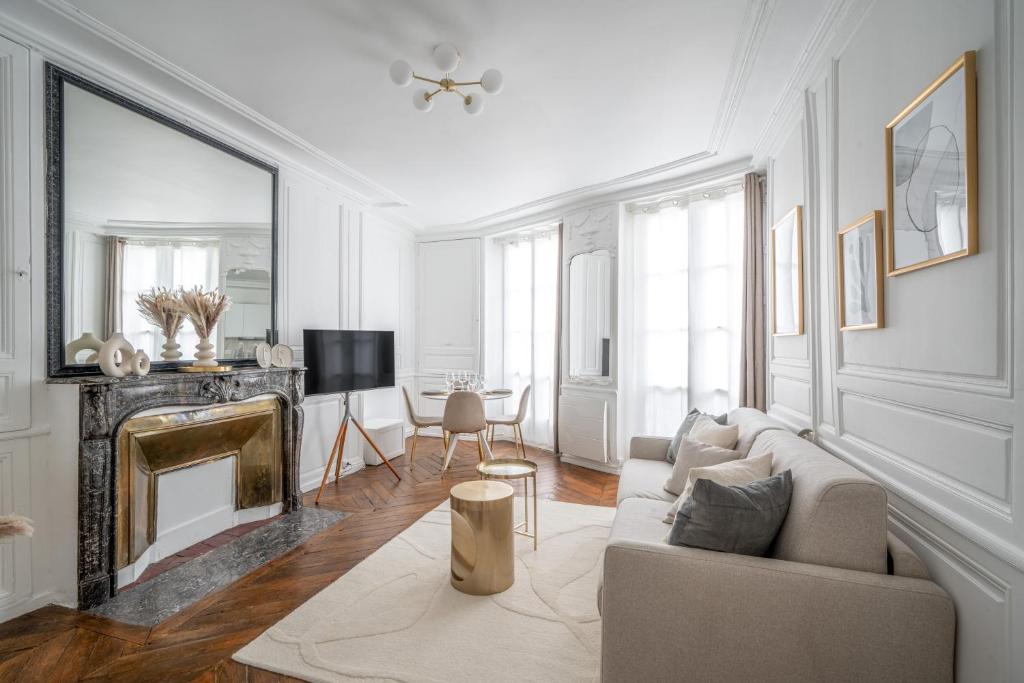 un salon avec un canapé et une cheminée dans l'établissement Le Versaillais - Proche Château de Versailles et 15 min RER Paris, à Versailles