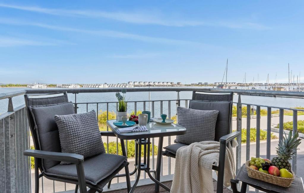 a table and chairs on a balcony with a view of the water at Strandläufer in Olpenitz