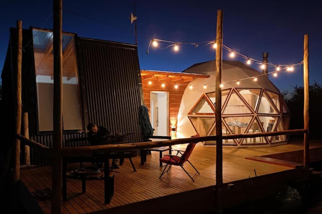 eine Person, die nachts an einem Tisch auf einem Deck sitzt in der Unterkunft Amawa Domo - escapada romántica en las sierras in San Francisco del Monte de Oro