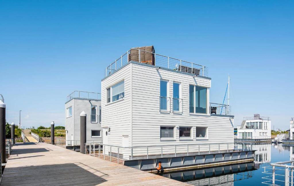 een wit huis op een dok naast het water bij Beluga in Olpenitz