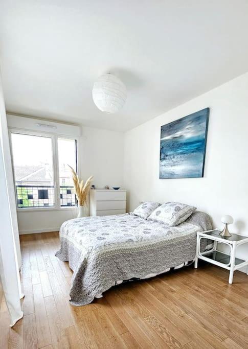 une chambre blanche avec un lit et une fenêtre dans l'établissement Charmant 2 pièces avec terrasse à 5 minutes de Paris, à Clichy