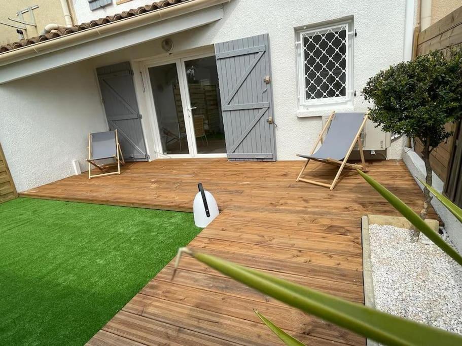 une arrière-cour avec deux chaises et une terrasse en bois dans l'établissement Les planètes du port, à Marseillan