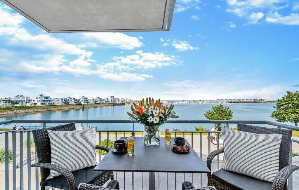 ein Tisch mit einer Vase mit Blumen auf einem Balkon in der Unterkunft Meerleben in Olpenitz