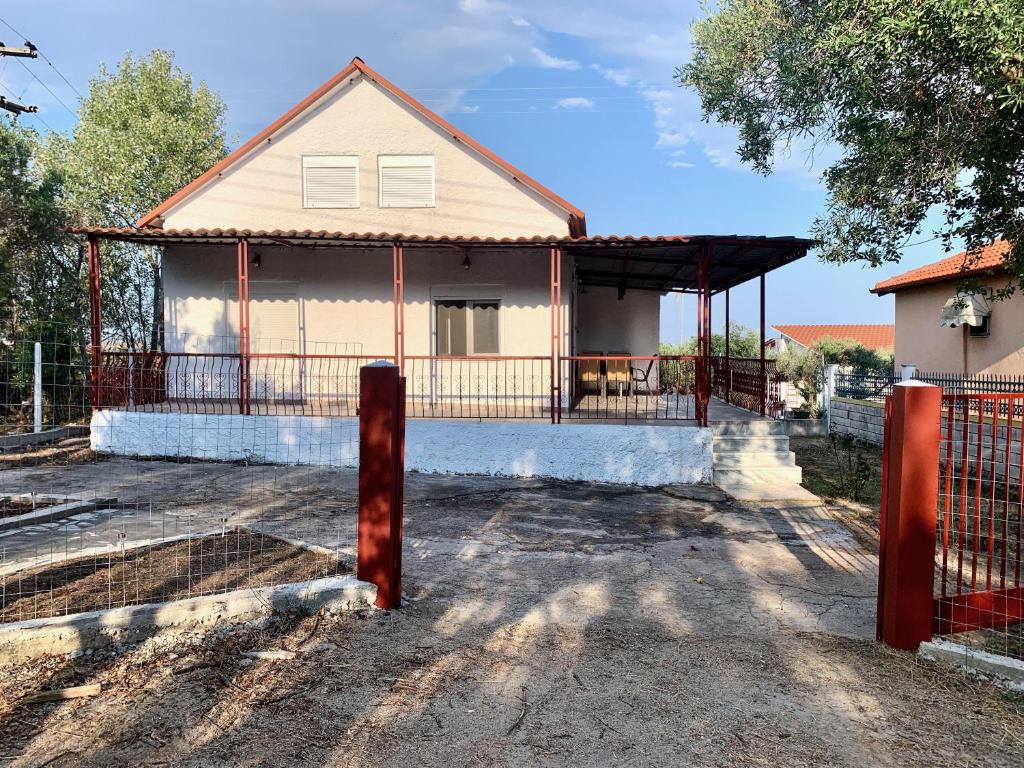 una casa con una recinzione davanti di Glykeraki's House a Nea Kalikratia