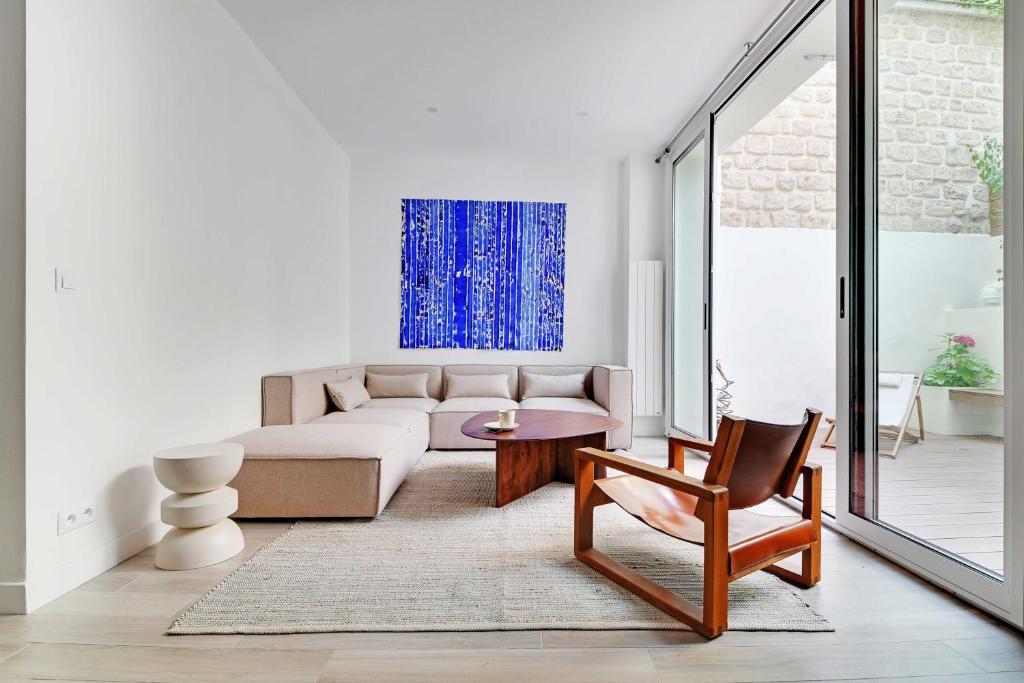 un salon avec un canapé et une chaise dans l'établissement Charming apt with patio - 2BD4P - Monceau Park, à Paris