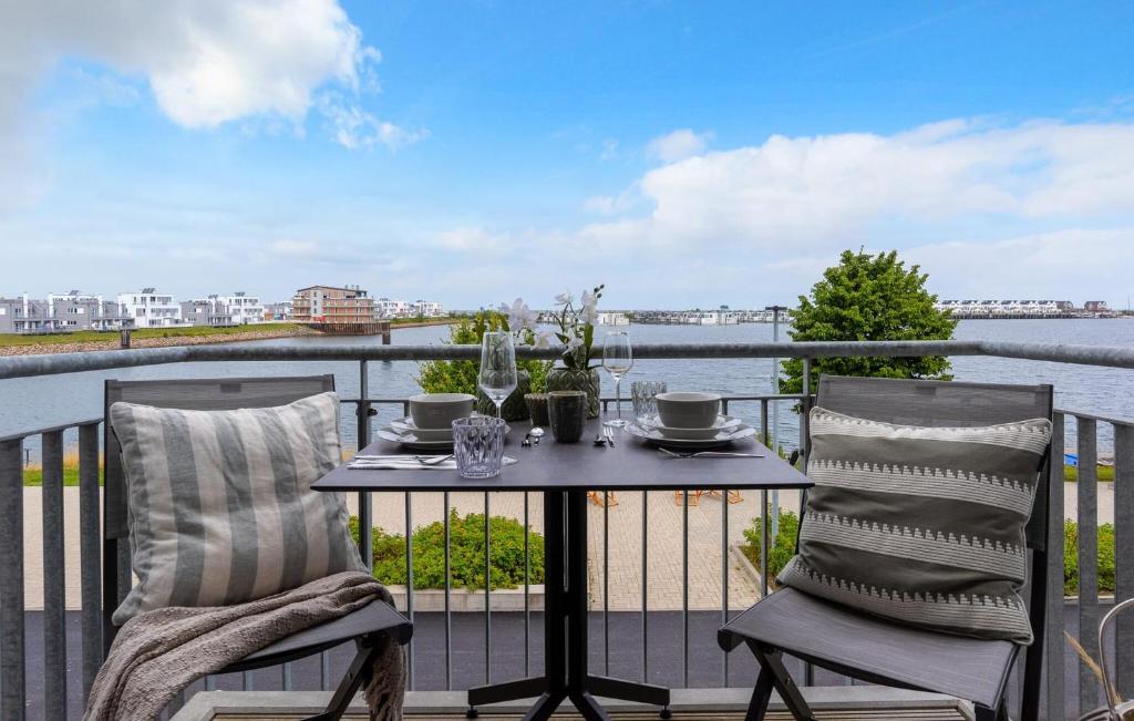 een tafel en stoelen op een balkon met uitzicht op het water bij Take Five in Olpenitz