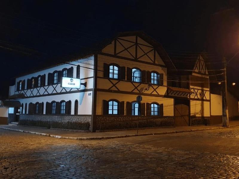 a building with lights in the windows at night at Casa Blanca Pousada Hotel in São Lourenço