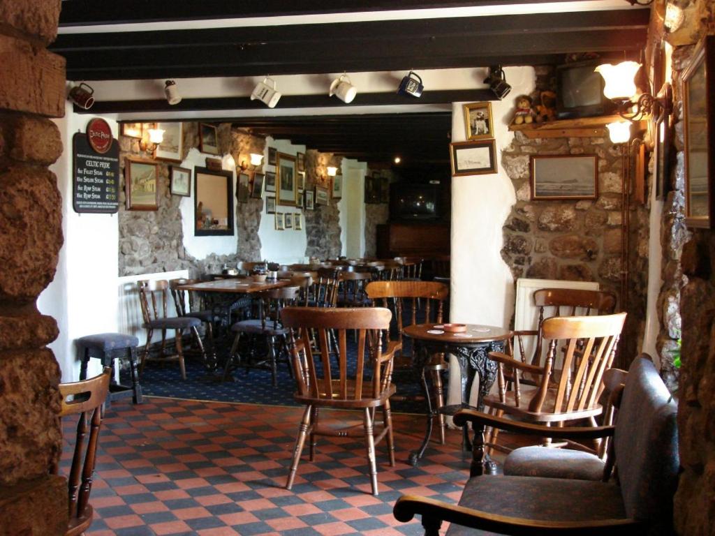 a restaurant with wooden chairs and tables in a room at King's Head Inn in Llangennith