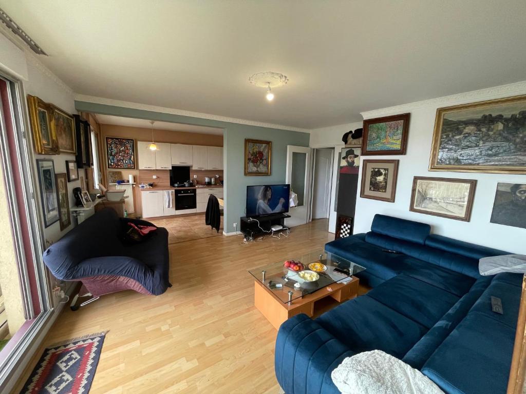 un salon avec un canapé bleu et une table dans l'établissement Havre de paix proche Paris, à Cachan