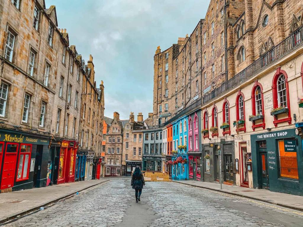 una persona che cammina lungo una strada di ciottoli in una città di Victoria Street View Flat in Edinburgh EB10 a Edimburgo