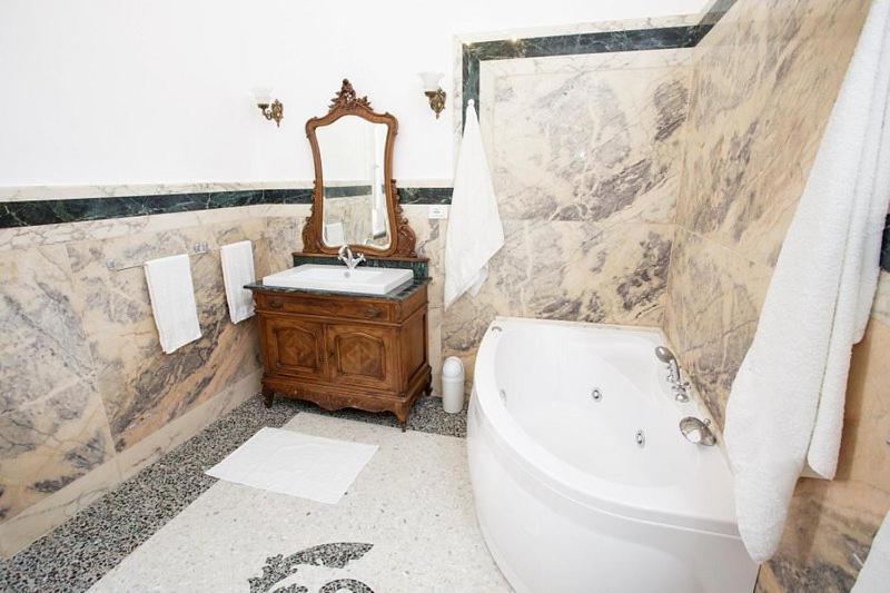 a bathroom with a tub and a sink and a mirror at Villa Degli Angeli in Nardò