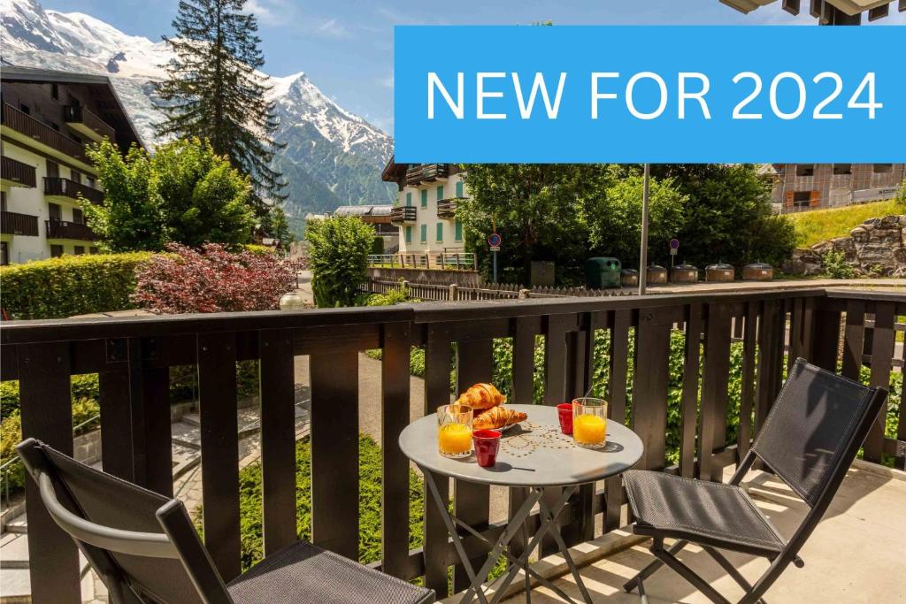 - une table avec 2 chaises et 2 boissons sur le balcon dans l'établissement Le Brevent 2 Apartment - Chamonix All Year, à Chamonix-Mont-Blanc