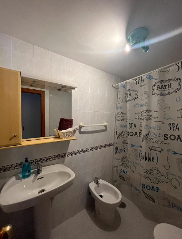 łazienka z umywalką, toaletą i lustrem w obiekcie APART CLUB LABARROSA w mieście Chiclana de la Frontera