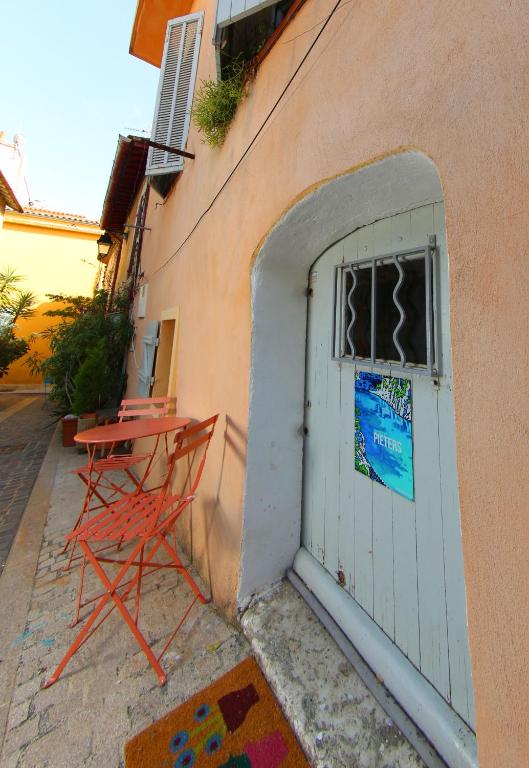 une chaise rouge assise devant une porte dans l'établissement studio au centre de Cassis, à Cassis