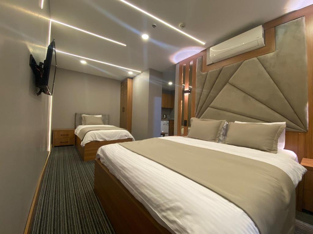a hotel room with two beds and a flat screen tv at istanbul vipinnhotels in Istanbul