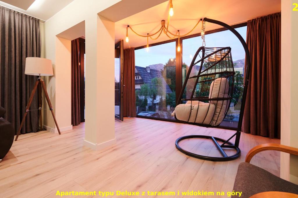 a living room with a large window with a swing at Apartamenty Widokowe Pod Lasem in Kościelisko