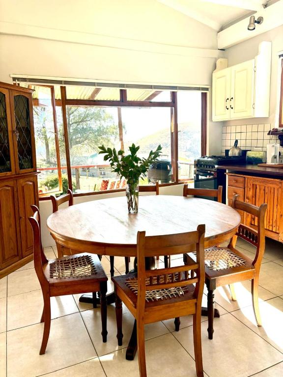 a kitchen with a wooden table with chairs and a table at Serena Cottage in Nottingham Road