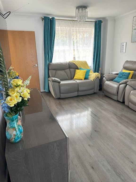 ein Wohnzimmer mit Sofa und Tisch in der Unterkunft Lavish 3 story house with full of comfort in Dagenham