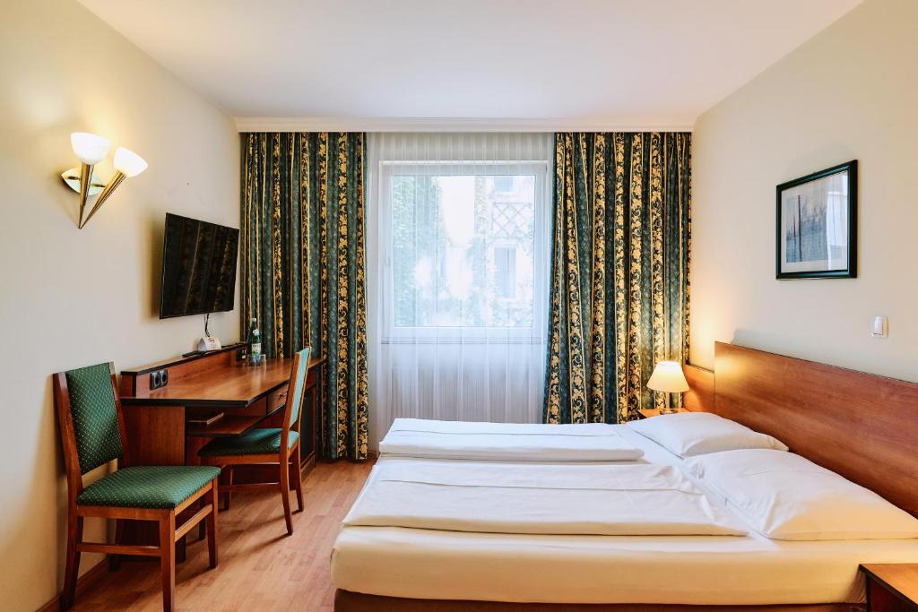 A bed or beds in a room at Hotel Deutschmeister
