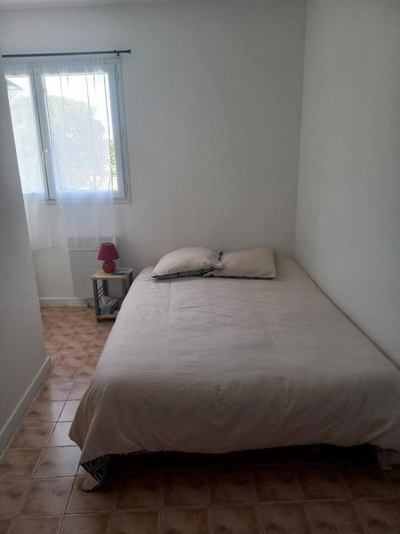 un lit dans une chambre blanche avec une fenêtre dans l'établissement Habitación Saint Herblain Cerca a Nantes, à Saint-Herblain