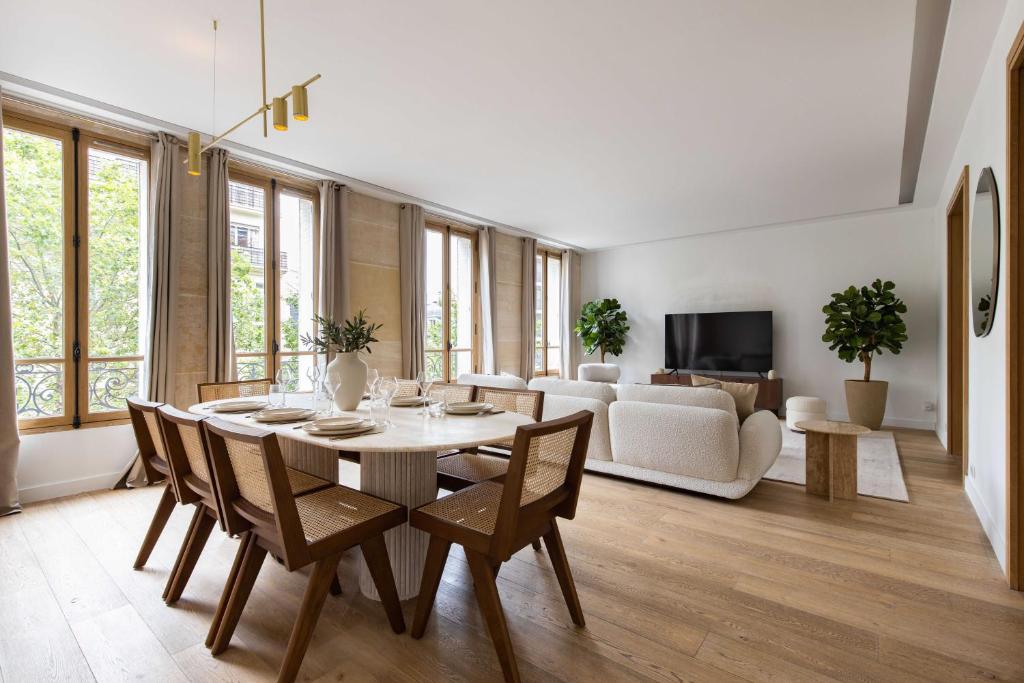 un salon avec une table, des chaises et un canapé dans l'établissement Sublime Apt - 3BD-6P - Arc De Triomphe, à Paris
